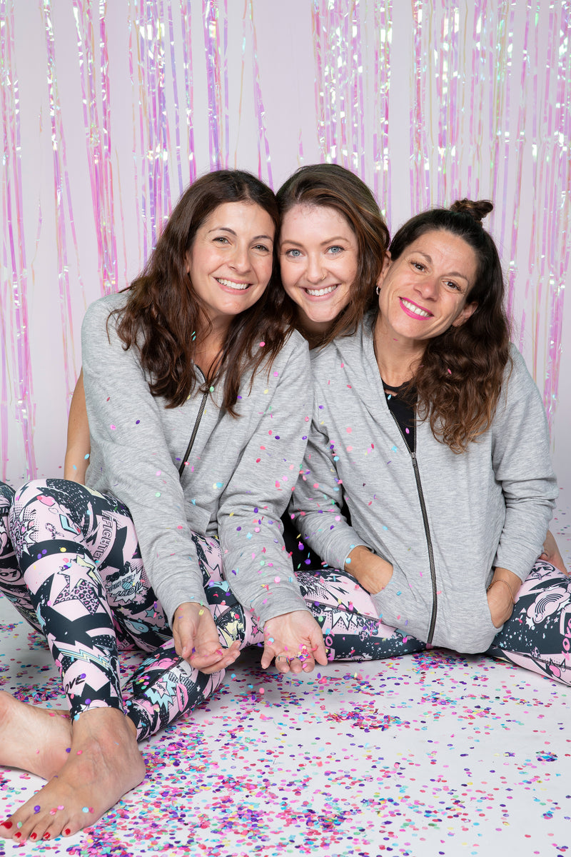 Group of women leaders sitting on a pink and white bed surface.