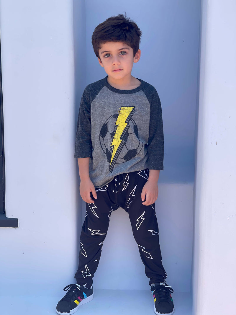 Young boy wearing a lightning strike long sleeve shirt and matching pants.